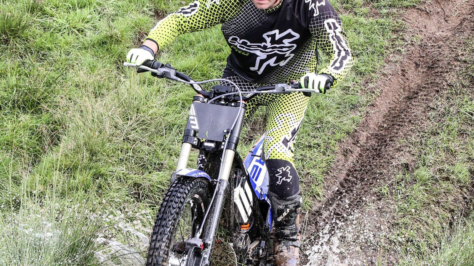 A trials bike crosses a stream